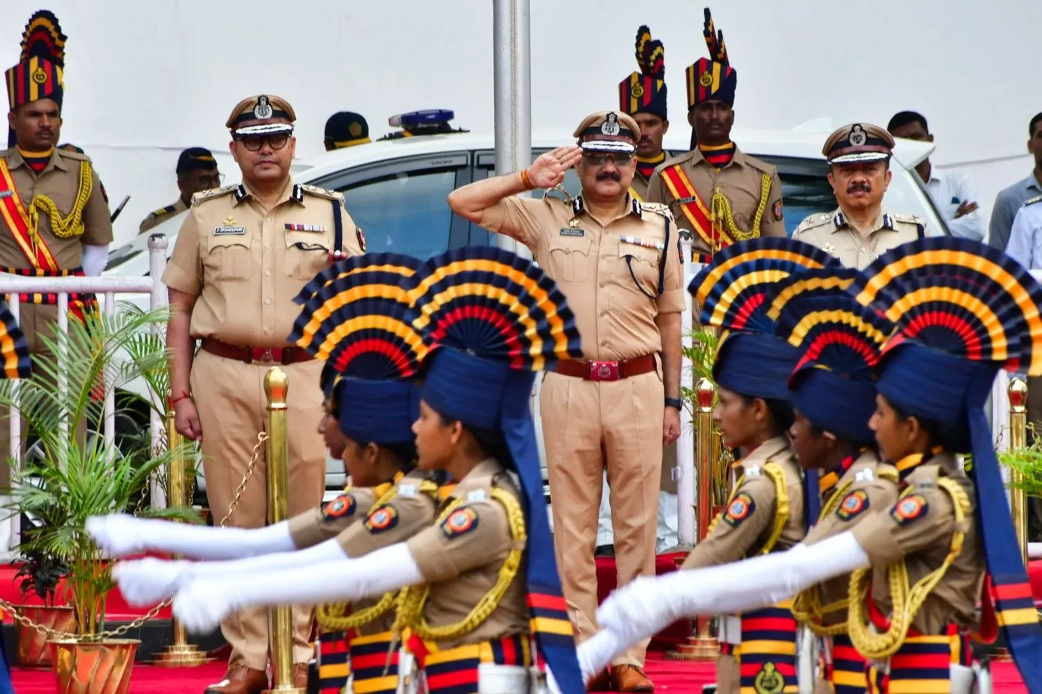Senior Mumbai Police officers on a ceremonial parade dais as a uniformed contingent marches past.