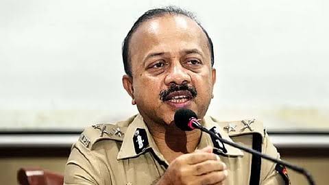 Deven Bharti addressing a press briefing at a microphone.