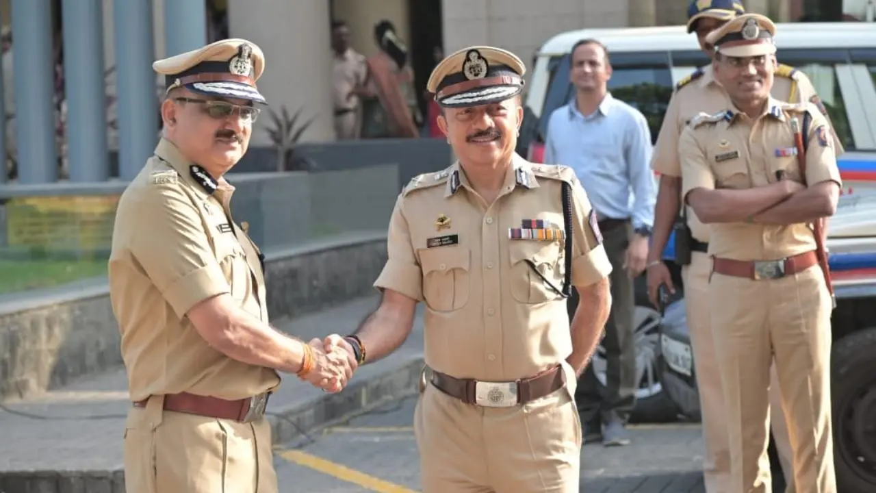 Deven Bharti shaking hands with a senior officer outside the Mumbai Police headquarters.