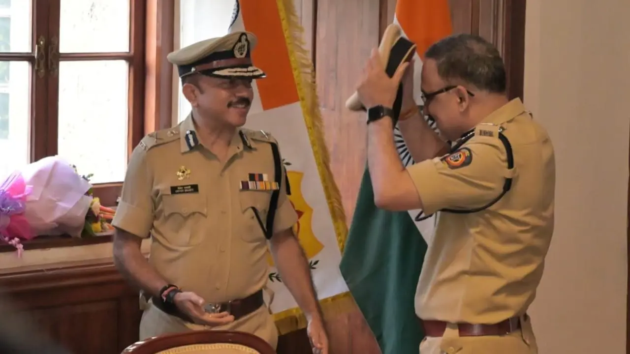Deven Bharti being felicitated by a colleague in a formal police office setting.